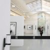 Boitier enrouleur de sangle blanc, sangle noire personnalisée "ARCO" fermant un couloir dans un musée Boitier enrouleur de sangle blanc, sangle noire personnalisée "ARCO" fermant un couloir dans un musée