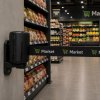 Enrouleur mural noir avec sangle de 3 mètres personnalisée avec un logo, fermant l'allée d'un supermarché. Enrouleur mural noir avec sangle de 3 mètres personnalisée avec un logo, fermant l'allée d'un supermarché.