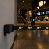 Enrouleur de sangle mural STANDARD noir avec sangle personnalisée avec logo dans une entrée de cinéma Enrouleur de sangle mural STANDARD noir avec sangle personnalisée avec logo dans une entrée de cinéma